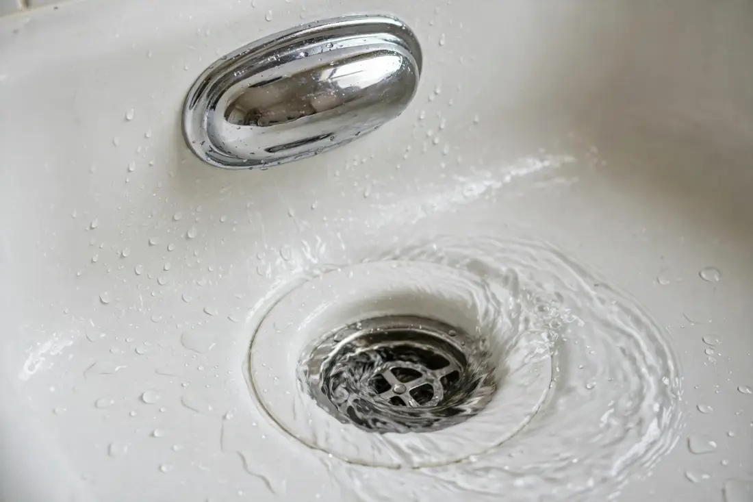 Water swirling down a bathtub drain